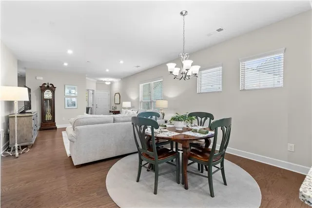 a dining room with furniture a chandelier and wooden floor