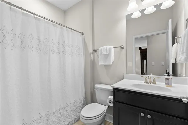 a bathroom with a sink vanity mirror and toilet