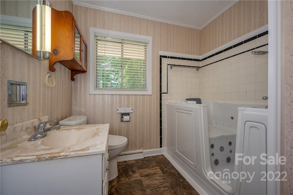 136 Crestview Street Rutherfordton, NC 28139 - Photo 7 of 34 a bathroom with a granite countertop sink a toilet and shower