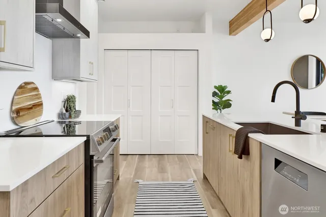 a kitchen with stainless steel appliances a sink a stove and cabinets