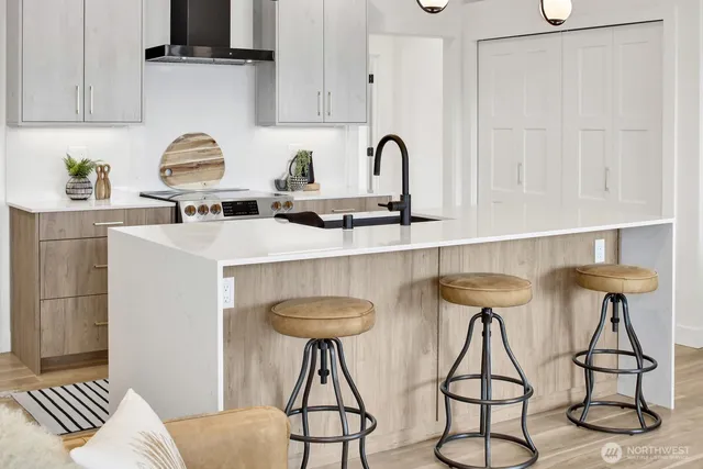 a kitchen with stainless steel appliances a kitchen island a stove a table and chairs in it