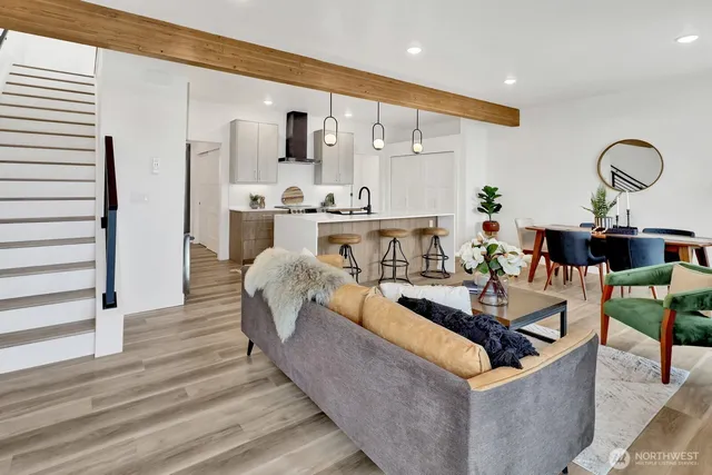 a kitchen with stainless steel appliances a table chairs in it and wooden floors