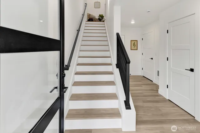 a view of staircase with wooden floor and white walls