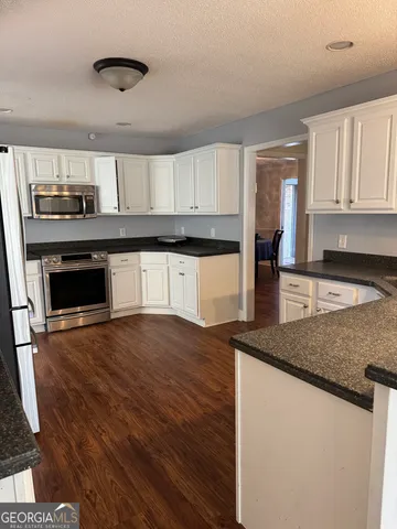 a kitchen with stainless steel appliances granite countertop a stove a sink and a microwave