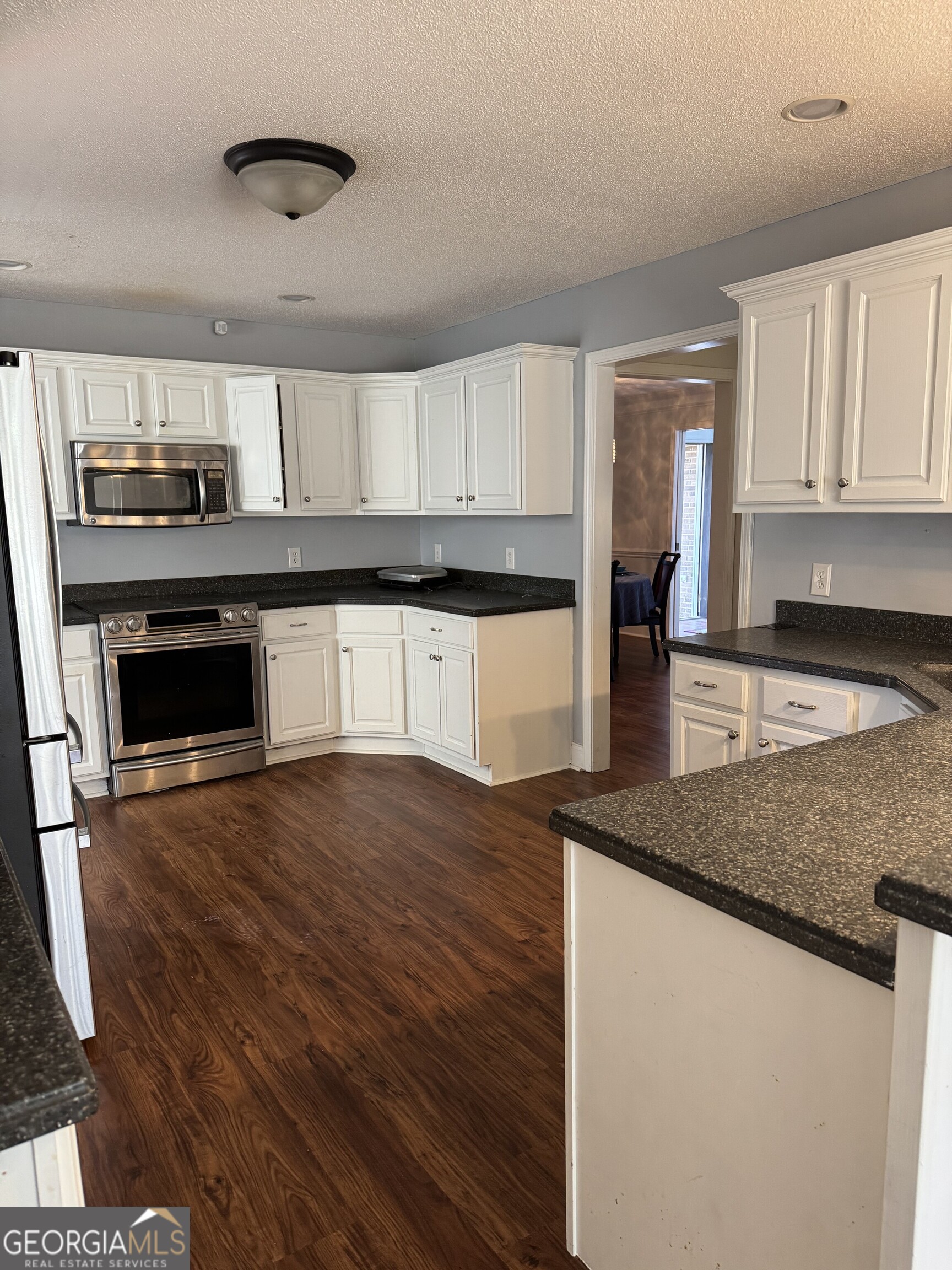 2132 Kings Chapel Road Perry, GA 31069 - Photo 12 of 13 a kitchen with stainless steel appliances granite countertop a stove a sink and a microwave