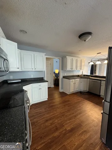 a kitchen with stainless steel appliances granite countertop a refrigerator and a stove top oven