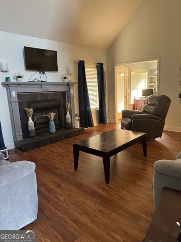 a living room with furniture a fireplace and a flat screen tv