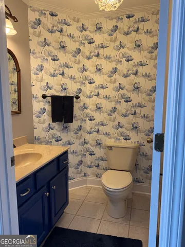 a bathroom with a granite countertop toilet sink and mirror