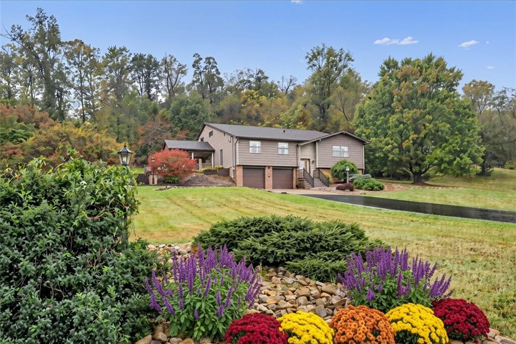 a view of a house with a big yard and potted plants
