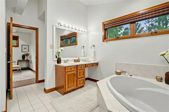 a bathroom with a tub sink and mirror