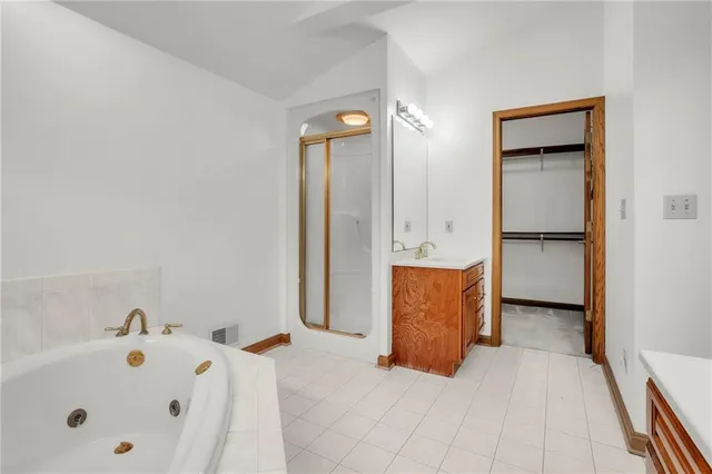 a bathroom with a tub sink and mirror