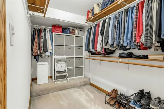 a view of walk in closet with clothes and shoes