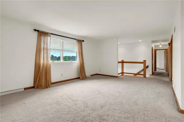 an empty room with a window and a kitchen