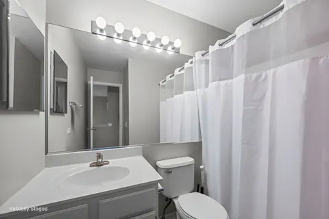 a bathroom with a sink vanity mirror and toilet