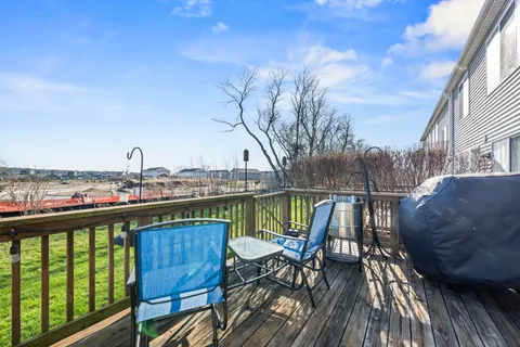 a view of a balcony with chairs and wooden floor