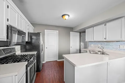 a kitchen with a sink a stove and cabinets