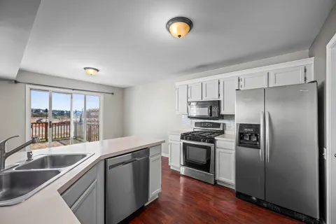 a kitchen with stainless steel appliances granite countertop a sink and a refrigerator