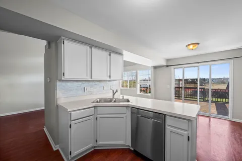 a kitchen with a sink cabinets and wooden floor
