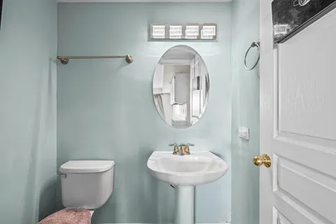 a bathroom with a toilet sink and mirror