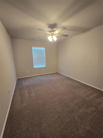 en empty room with windows and fan