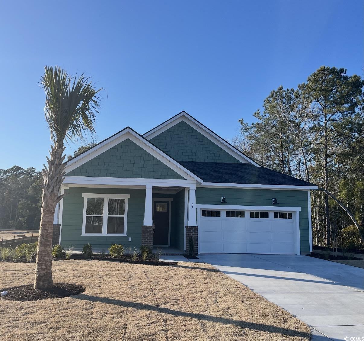 Craftsman-style house featuring a porch, driveway, and a garage