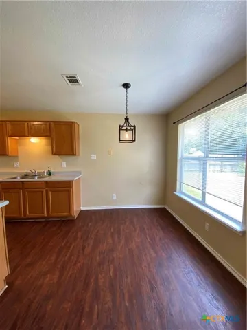 a view of a kitchen with wooden floor and a sink