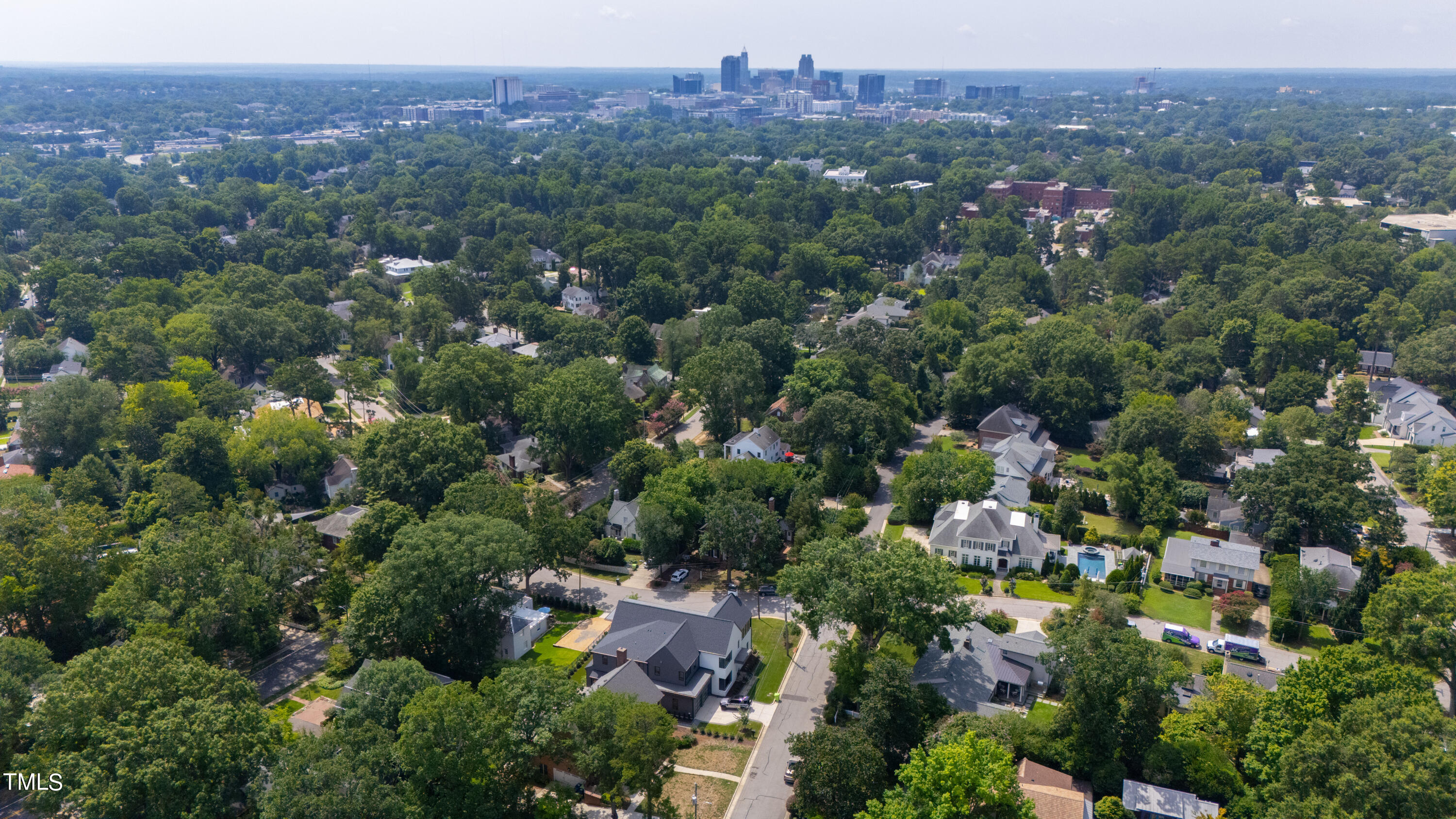 1804 Mcdonald Lane Raleigh, NC 27608 - Photo 60 of 62 an aerial view of a city with lots of residential buildings and mountain view in back