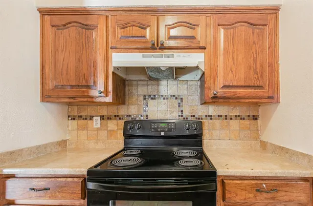 a stove top oven sitting inside of a kitchen