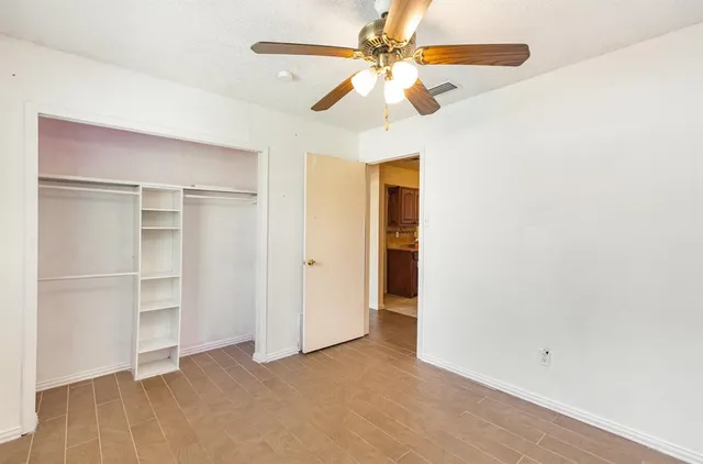 a view of an empty room with a ceiling fan