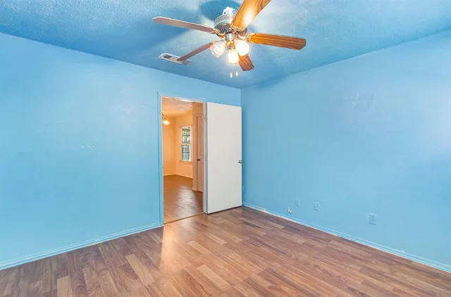 an empty room with a window and a ceiling fan