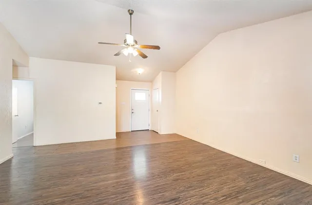 a view of empty room with wooden floor