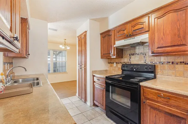 a kitchen with granite countertop a sink and a stove top oven