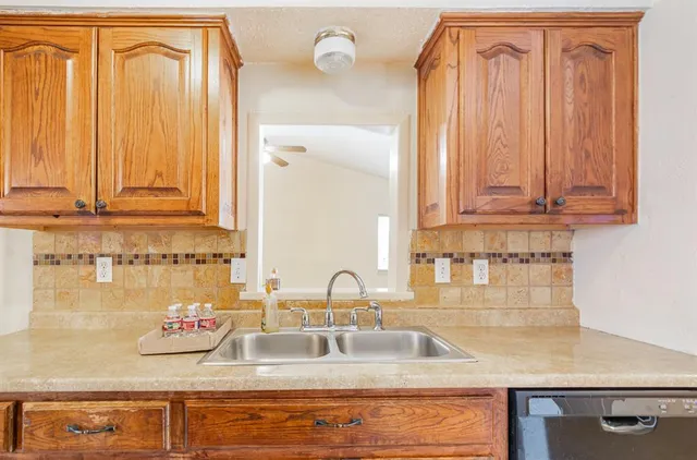 a kitchen with granite countertop a sink and cabinets