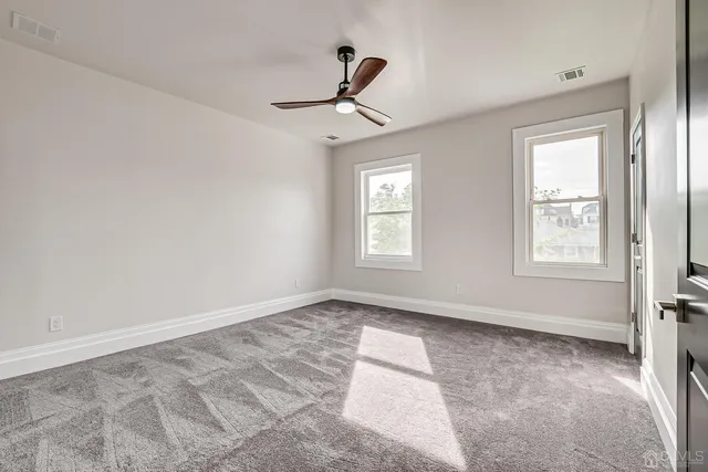 a view of empty room with ceiling fan