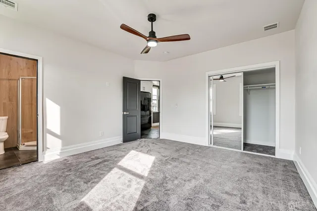 a view of empty room with wooden floor and ceiling fan
