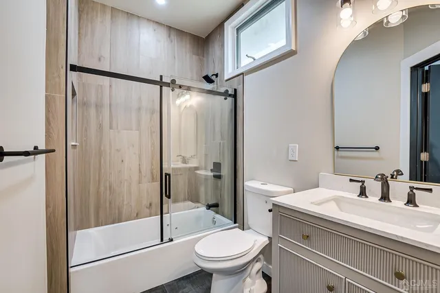 a bathroom with a granite countertop sink toilet and shower
