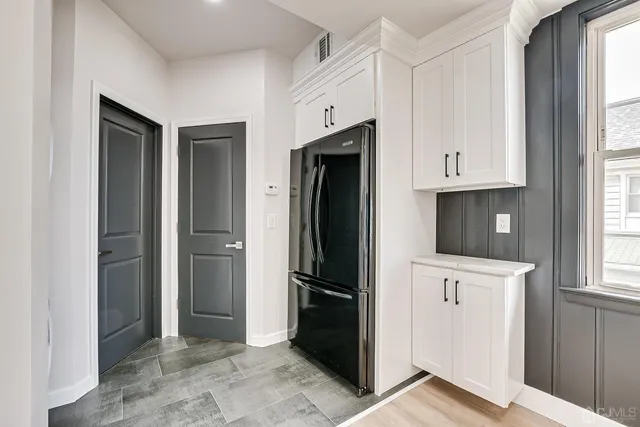 a view of kitchen with refrigerator and window