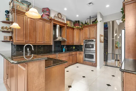 a kitchen with stainless steel appliances granite countertop a stove a sink and a microwave