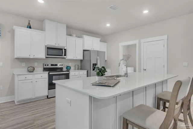 a kitchen with white cabinets and stainless steel appliances