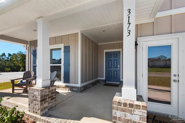 a view of a door and chair in front of house