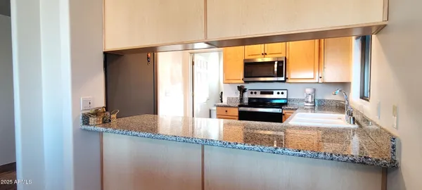 a kitchen with granite countertop a sink and a stove top oven
