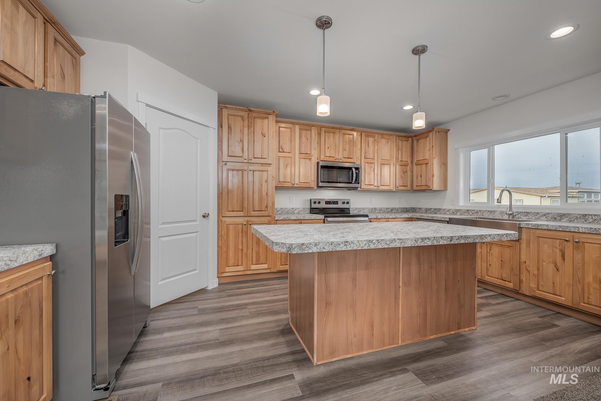 2750 Alden Road, Unit 8 8 Fruitland, ID 83619 - Photo 4 of 31 Kitchen featuring stainless steel appliances, light countertops, pendant lighting, a kitchen island, and dark wood-style floors