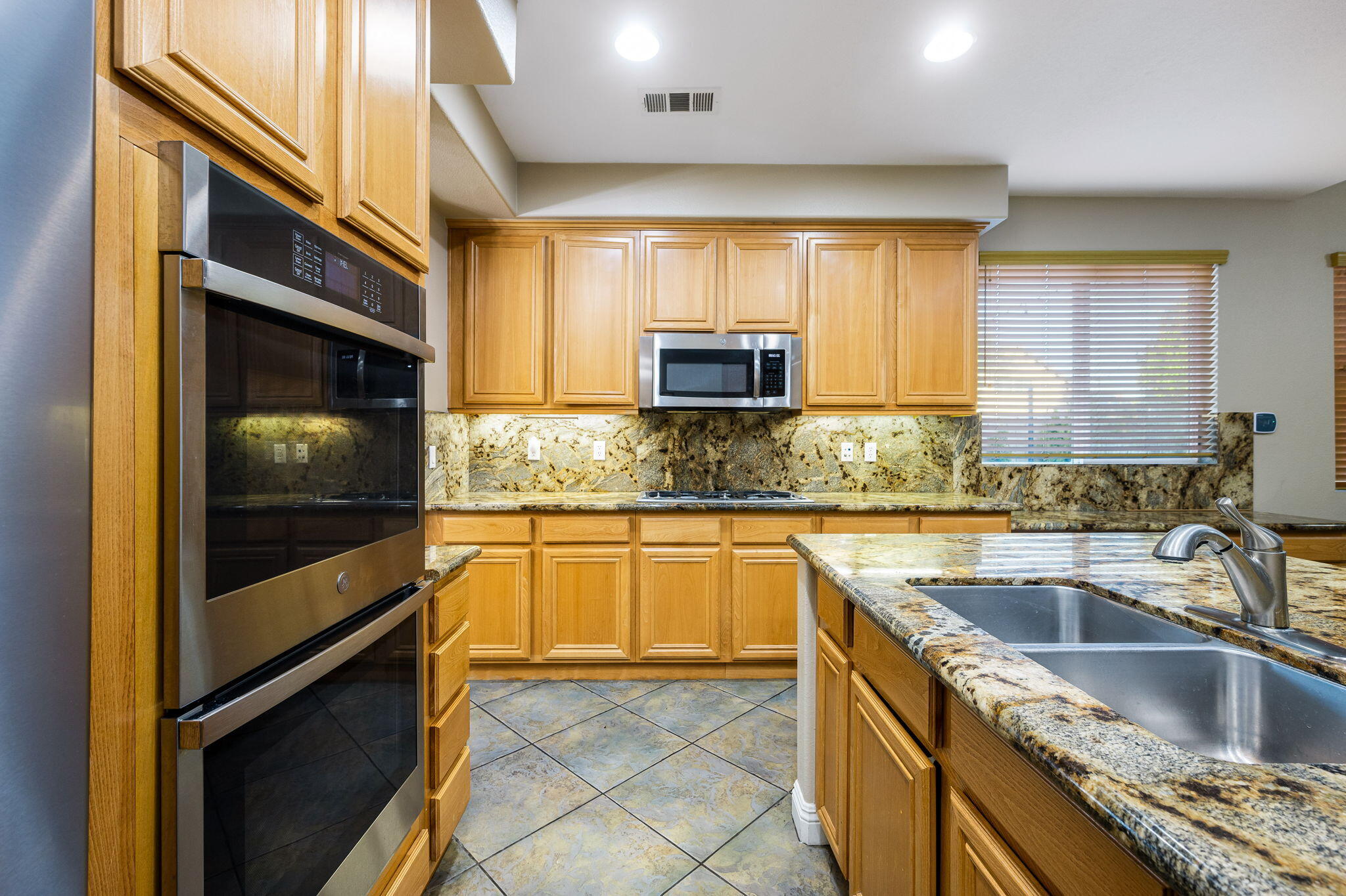 80510 Denton Drive Indio, CA 92203 - Photo 24 of 80 a kitchen with kitchen island granite countertop a sink stove and cabinets