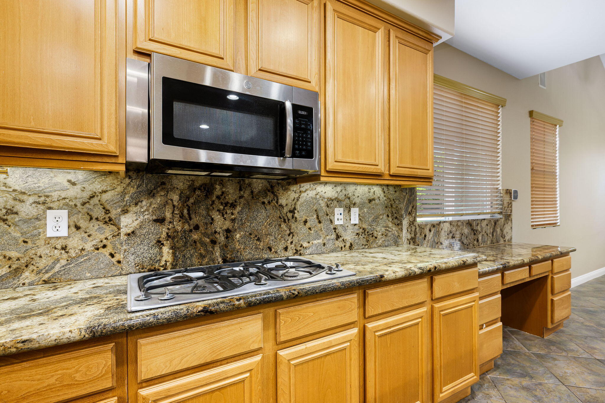 80510 Denton Drive Indio, CA 92203 - Photo 25 of 80 a kitchen with granite countertop a stove top oven microwave and cabinets