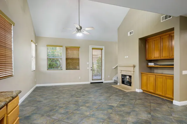 an empty room with windows and fan