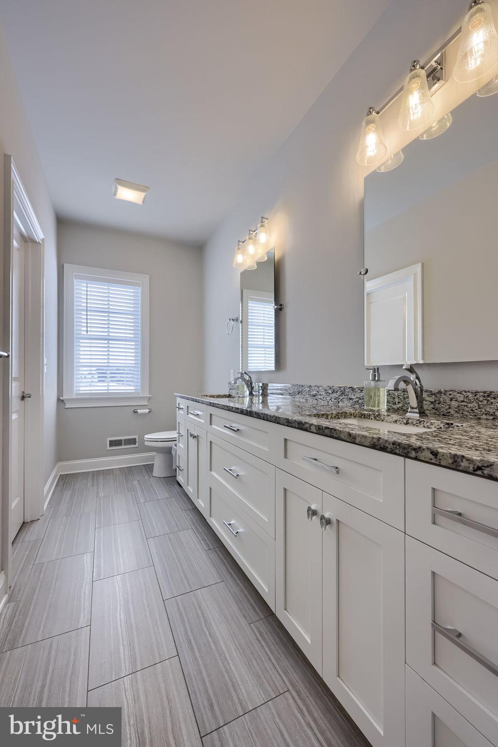 512 East Delp Road Lancaster, PA 17601 - Photo 39 of 75 a spacious bathroom with a granite countertop sink toilet a large mirror a bathtub and window