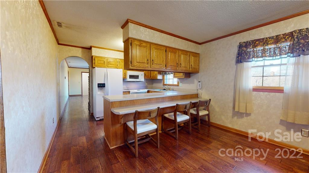 219 Ridge Road Marion, NC 28752 - Photo 12 of 28 a dining room with stainless steel appliances granite countertop furniture wooden floor and a window