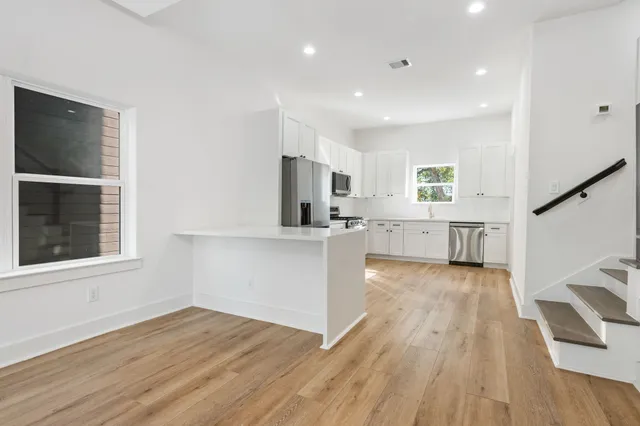 a view of a kitchen with wooden floor and a window