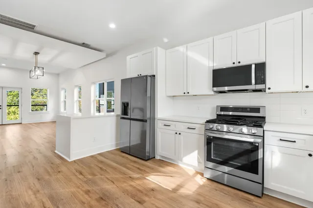 a kitchen with stainless steel appliances a stove a refrigerator and a microwave