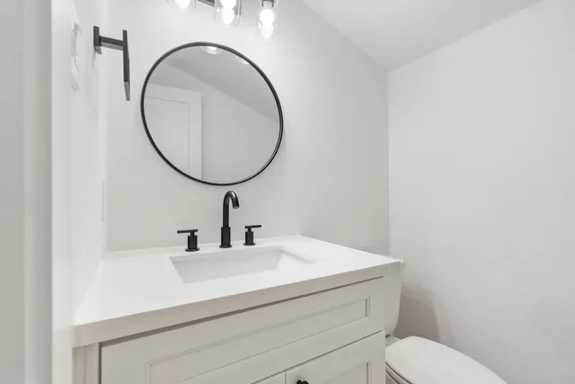 a bathroom with a sink a mirror and a toilet